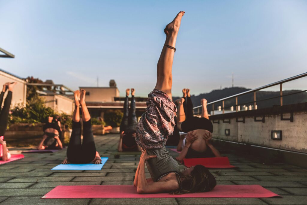 pexels-photo-1375883-1375883 People practicing yoga on mats outdoors during sunset, focusing on wellness.